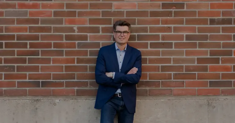 Sami Puutio nojaamassa tiilisenää vasten