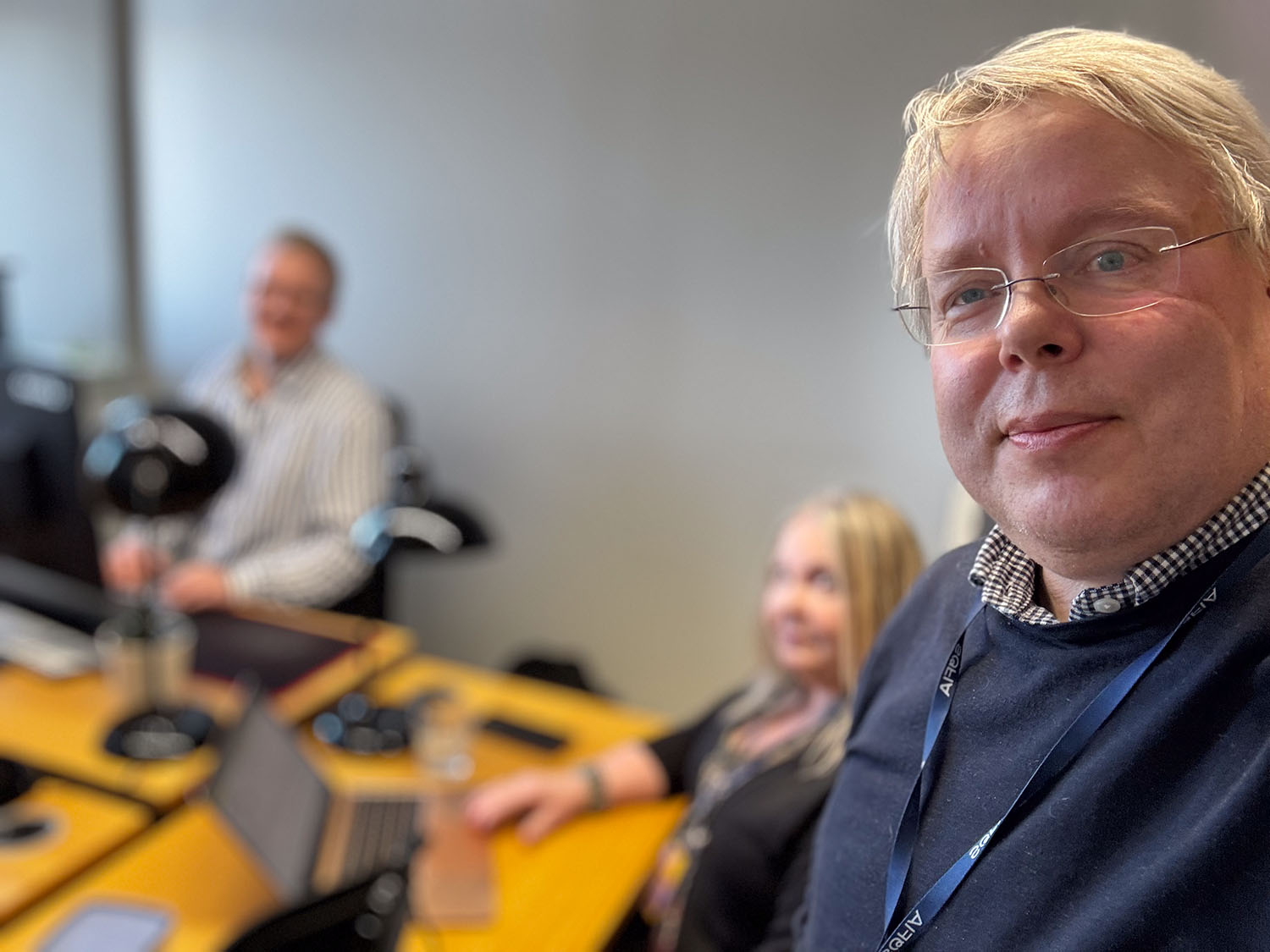 Oikealla Mika Särkijärvi pohtimassa miten tekoäly vaikuttaa sisältömarkkinointikentän tulevaisuudessa. Taustalla sumeana näkyy kaksi muuta viestintätoimisto Meditan työntekijää.